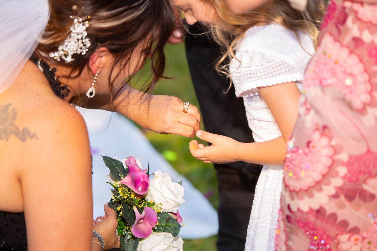 Bride shows a small girl her wedding ring.